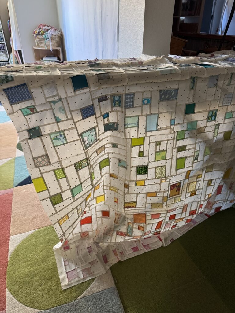 Colorful modern patchwork quilt top in progress with polka dot sashing