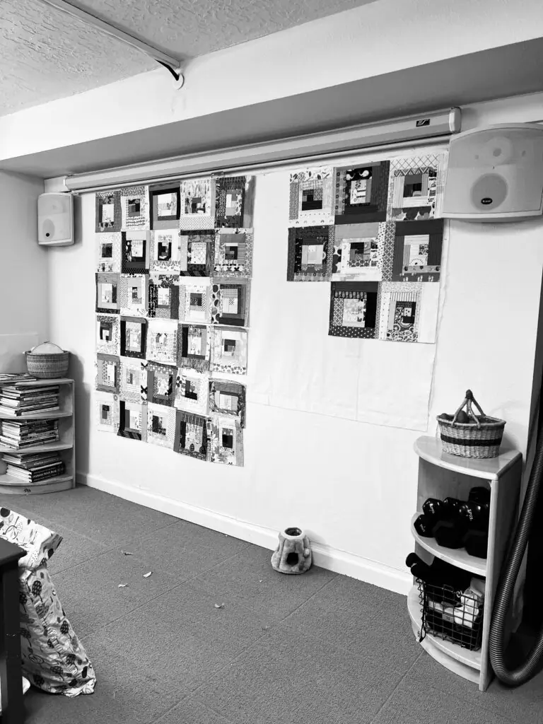 Log cabin quilt blocks pinned on design wall in home studio