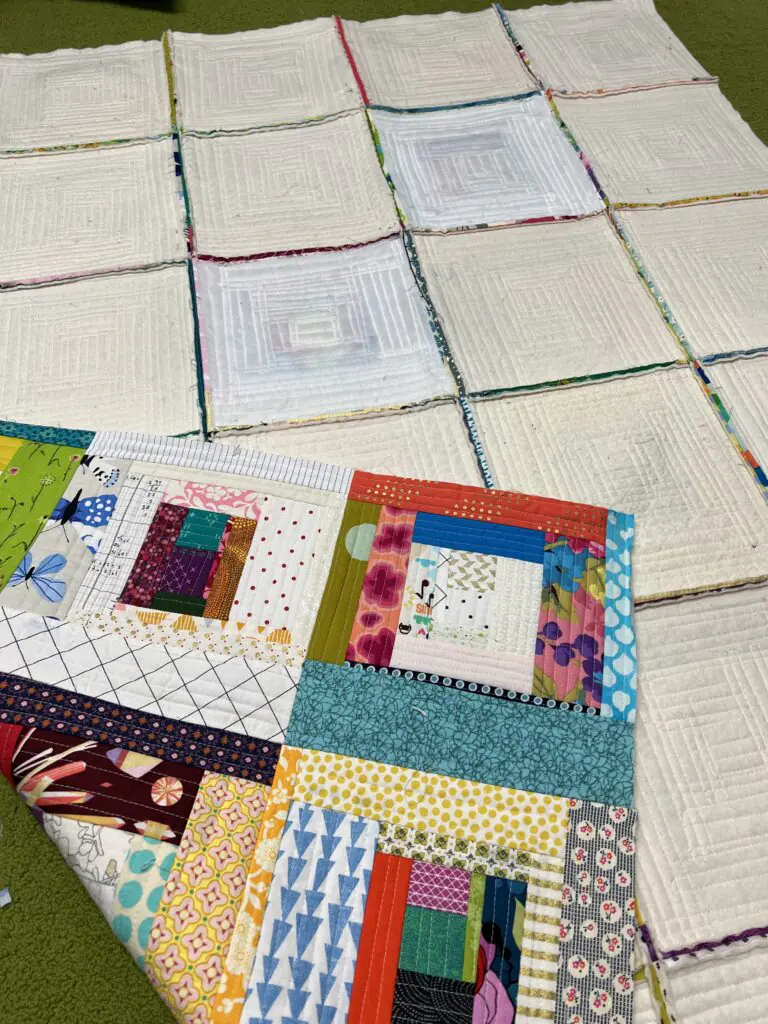 Handmade Colorful Log Cabin Quilt Blocks Laid Out on White Rag Quilt