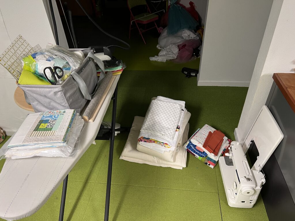 Quilting workspace with fabric stacks and sewing machine