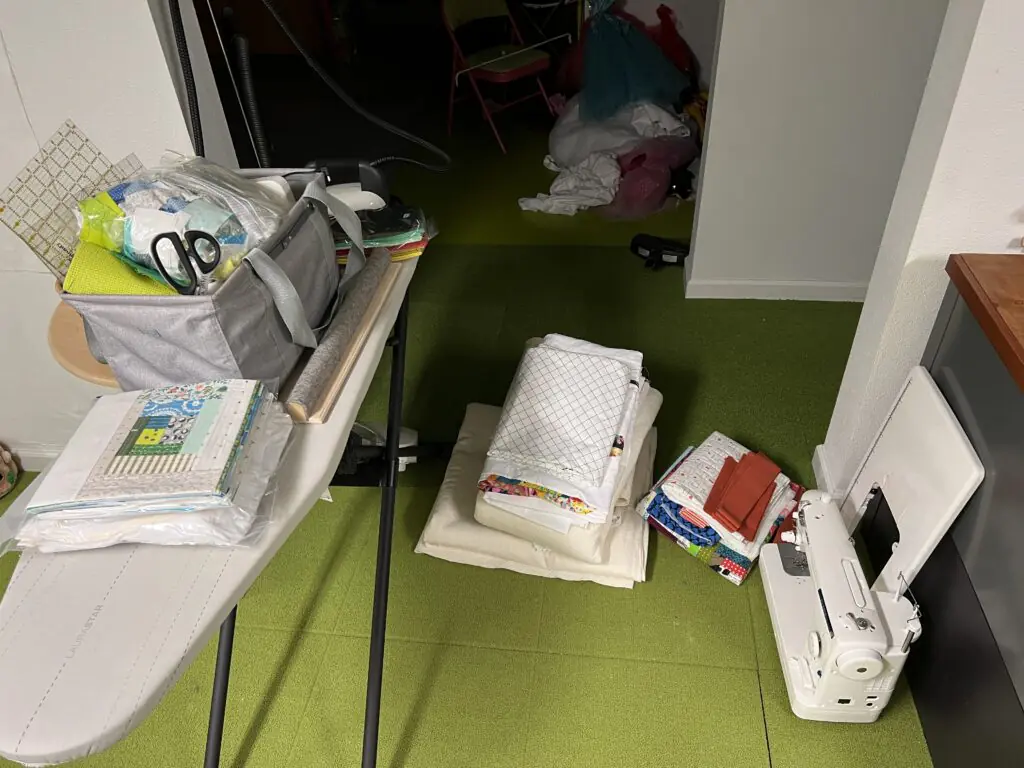 Quilting workspace with fabric stacks and sewing machine