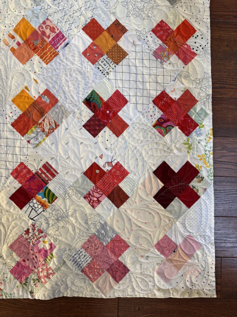 Crosses on Point quilt with red, pink and orange patchwork
