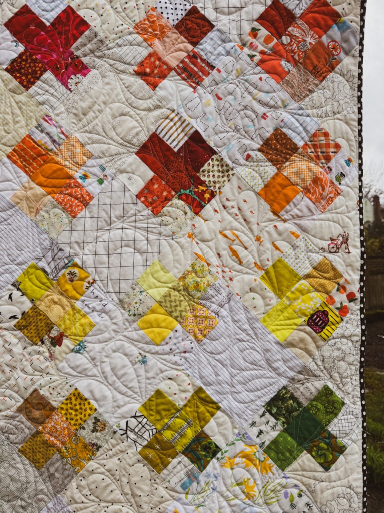 Scrappy Crosses Quilt with Colorful Patchwork and Hand Quilting