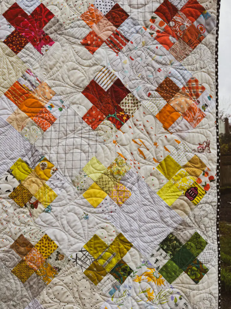 Scrappy Crosses Quilt with Colorful Patchwork and Hand Quilting